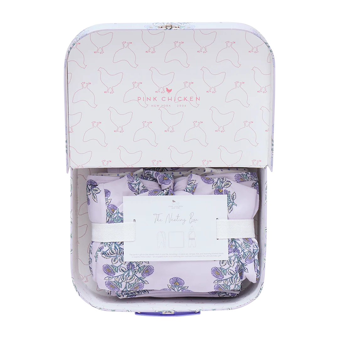 The Pink Chicken Nesting Box Baby Take Home Set features folded floral organic pima cotton fabric in a pastel chicken-patterned gift box with an info card, making it a perfect newborn gift.