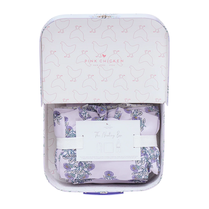The Pink Chicken Nesting Box Baby Take Home Set features folded floral organic pima cotton fabric in a pastel chicken-patterned gift box with an info card, making it a perfect newborn gift.