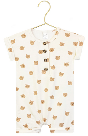 Short-sleeve, cream-colored Baby Boys’ Teddy Romper by Lou Lou & Company, featuring an adorable brown bear faces pattern and three dark buttons on the front, displayed on a gold hanger—a charming one-piece perfect for your little one’s comfort.