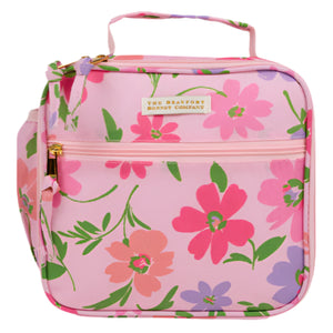 The Beaufort Bonnet Company’s Leighton Lunch Box in pink features a floral pattern in green, red, and purple, plus a front zipper pocket, side pocket, and top handle—a stylish lunchbox for kids.