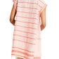 A person is seen from behind in the lemlem Elina Caftan by Lemlem, a sleeveless pink and white striped A-line dress with red accents and a fringed hem, crafted meticulously from hand-spun cotton for a unique touch.