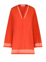 The Lemlem Raey Dress by Lemlem is a chic, bright orange tunic hand-woven in Ethiopia. It features a V-neck, long sleeves, and white zigzag trim on the neckline, cuffs, and hem, along with delicate sheer stripes for elegance.