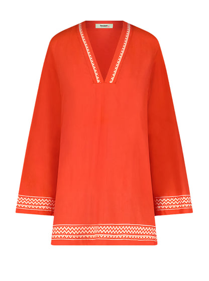 The Lemlem Raey Dress by Lemlem is a chic, bright orange tunic hand-woven in Ethiopia. It features a V-neck, long sleeves, and white zigzag trim on the neckline, cuffs, and hem, along with delicate sheer stripes for elegance.