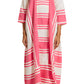 A model in the Lemlem Fana Caftan, featuring pink and white stripes and three-quarter sleeves, pairs it with open-toe woven slippers against a plain background for a versatile look.