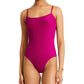The person is wearing the lemlem Elene One Piece by Lemlem, a vibrant pink swimsuit with adjustable spaghetti straps and a chic ribbed texture.