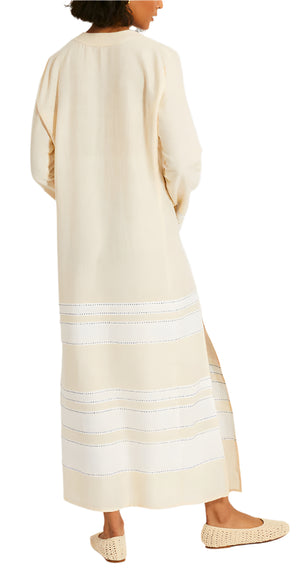 A person sideways, wearing Lemlem's Theodora Column Dress in cream with horizontal stripes.