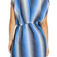 A woman is seen from the back wearing Lemlem's Alem Dress—a short-sleeve, blue and white vertically striped, hand-spun cotton dress with a cinched waist and loose fit, ideal for chic resort style.