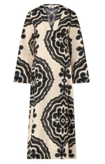 The Lemlem Theodora Column Dress is a long-sleeved, cream linen maxi with a V-neck and bold black geometric patterns for a striking bohemian look.
