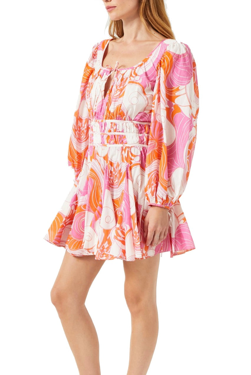 A woman wearing a long-sleeve, floral-patterned Rhode Leona Dress in pink, orange, and white, with a square neckline and fitted waist, crafted from soft Cotton Cambric Fabrication.