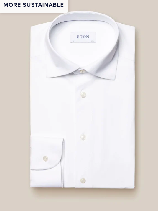 A neatly folded white Four-Way Stretch Shirt, Slim Fit by Eton with classic collar and buttoned cuffs lies on a beige background. Made from breathable tech fabric, it features a "MORE SUSTAINABLE" tag in the top left corner.