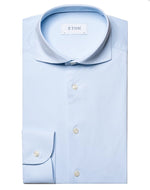 A neatly folded, light blue Eton Four-Way Stretch Shirt, Contemporary Fit with a button-down collar and white buttons, made from luxurious tech fabric for exceptional comfort, displayed against a white background.