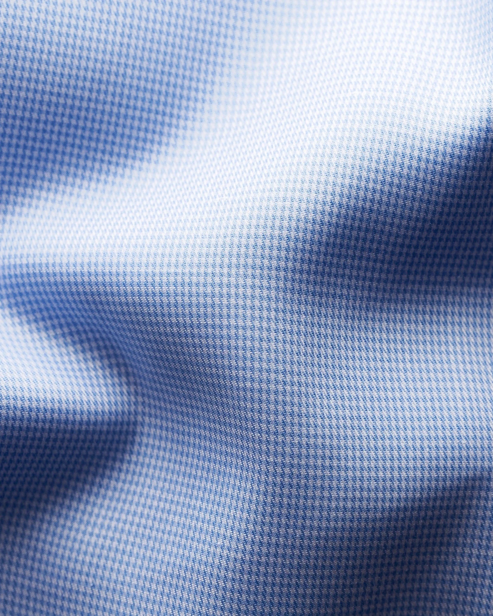 Close-up of light blue and white houndstooth fine twill fabric with visible folds and shadows, from Eton’s Contemporary Houndstooth Fine Twill Shirt.