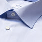 Close-up of the light blue Eton Light Blue Signature Twill Shirt in a slim fit, featuring a pointed collar and two visible buttons. The brand's signature twill fabric and wrinkle-free design are highlighted, with a partial view of the "ETON" label visible.