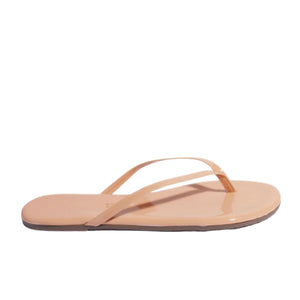 The Tkees Lily Glosses Sandals are nude-colored Brazilian leather flip flops with thin straps and a flat sole, shown in a side view on a white background.