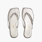 The Tkees Lily Square Toe Metallic Sandal features thin straps and a modern square-toe design in metallic silver, shown on a white background.