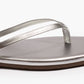 Close-up of the Tkees Lily Square Toe Metallic Sandal, featuring thin straps and a flat sole in metallic silver, displaying clean lines and modern design against a white background.