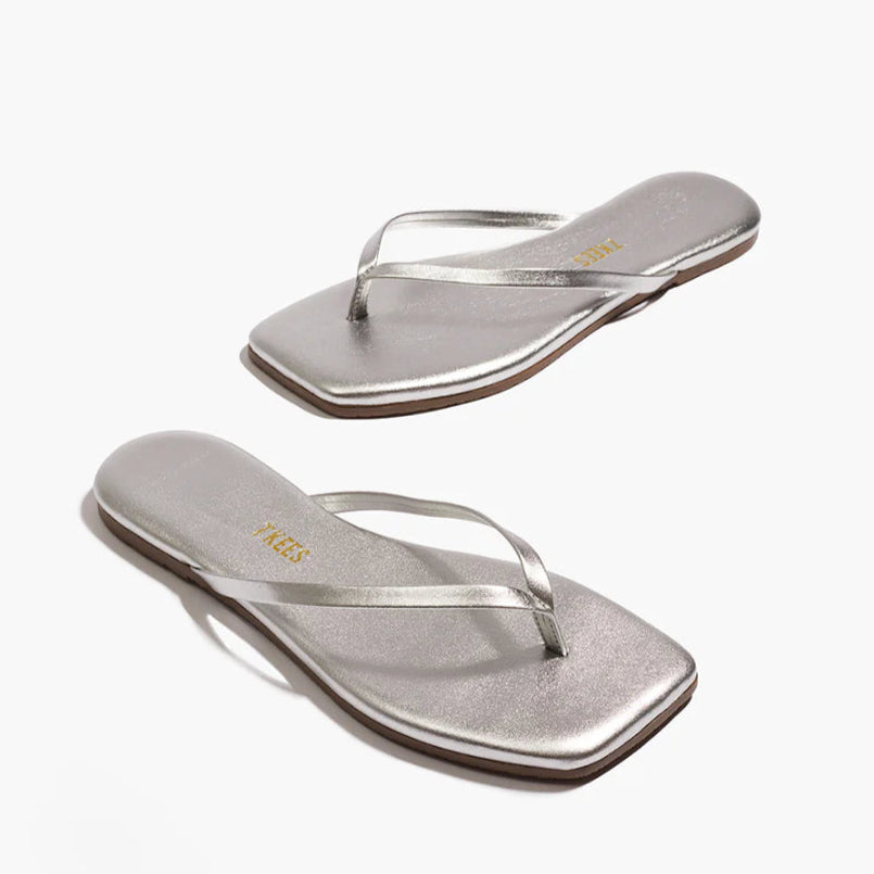 The Tkees Lily Square Toe Metallic Sandal features thin straps and a square toe in silver, highlighting its clean lines and modern design on a white background.