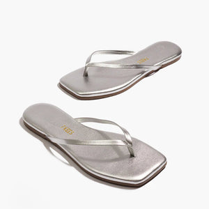 The Tkees Lily Square Toe Metallic Sandal features thin straps and a square toe in silver, highlighting its clean lines and modern design on a white background.