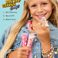 A smiling girl in a denim jacket holds tubes of lip gloss and a mixing tool. Text on the image shows steps for a DIY gloss project: Mix & Shimmer, Blend & Fill, Make It Yours. The Super Smalls Create Your Own Lip Gloss kit features kid-safe ingredients and invites kids to get creative with every unique gloss they make.