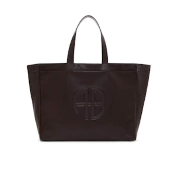The Anine Bing Large Rio Tote is a spacious dark brown leather bag with two handles and a raised AB monogram on the front.