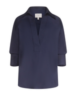TWP Polo Shirt in navy blue featuring long sleeves, a deep V-neck, wide collar, and cuffed sleeves displayed on a plain white background.