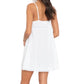 Model wearing the Anna Dress by Xirena—a short, white cotton poplin slip dress with lace trim—shown from the back against a white background.