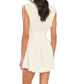 A woman shown from the back against a white background wears the Xirena Thelma Dress, a sleeveless cream-colored style featuring a smocked waist and frayed hem.