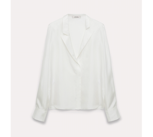 The Dorothee Schumacher Trench It Up Blouse is a white silk twill top with long sleeves, an asymmetric notched lapel, and wide cuffs, shown on a light background. Its fluid drape highlights the elegant silhouette.