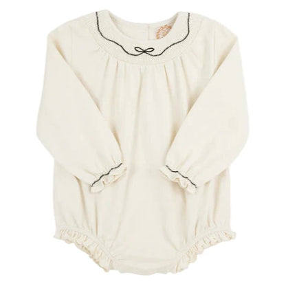 The Beaufort Bonnet Company’s Baby Girls' Long Sleeve Bridget Bubble is a cream romper with black trim and ruffle accents on the collar, cuffs, and leg openings, offering a classic smocked bubble style.