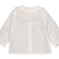 The Kidiwi Baby Girls' Lorena Blouse is a sheer off-white plumetis shirt with long sleeves, a ruffled Peter Pan collar with pink embroidery, buttoned cuffs, and a subtle dotted pattern.