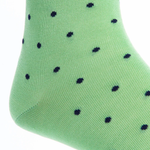 A close-up of Dapper Classics' Dot Mid Calf Socks showcases their green, durable fabric adorned with small black polka dots.