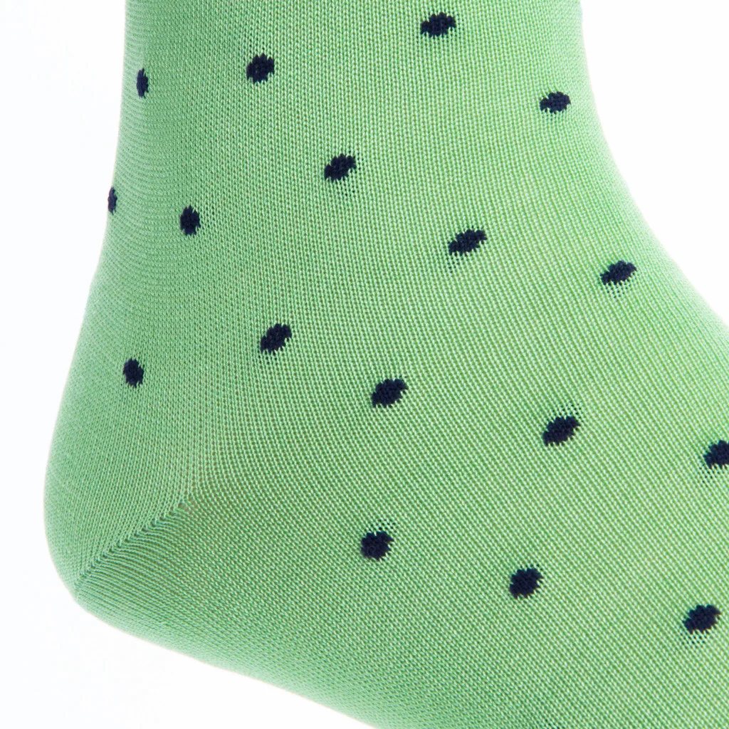 A close-up of Dapper Classics' Dot Mid Calf Socks showcases their green, durable fabric adorned with small black polka dots.