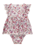 The Louise Misha Baby Girls’ Lena Romper features a dress-style design with ruffled cap sleeves, delicate lace trim, and a charming pink and purple floral pattern on crisp white cotton.