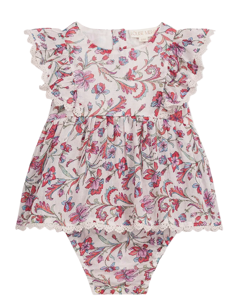 The Louise Misha Baby Girls’ Lena Romper features a dress-style design with ruffled cap sleeves, delicate lace trim, and a charming pink and purple floral pattern on crisp white cotton.