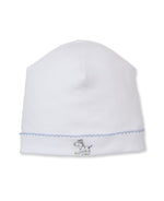 The Kissy Kissy Baby SCE Safari Party Hat is a white baby hat with blue trim, made from soft Pima cotton and adorned with delicate hand-embroidered zebra detailing on the front.