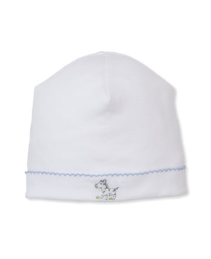 The Kissy Kissy Baby SCE Safari Party Hat is a white baby hat with blue trim, made from soft Pima cotton and adorned with delicate hand-embroidered zebra detailing on the front.