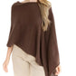 A woman stands against a white background wearing the Alashan Cashmere Cashmere Dress Topper Poncho in brown, styled effortlessly with light beige pants—a versatile look ideal for transitioning seamlessly from day to night.