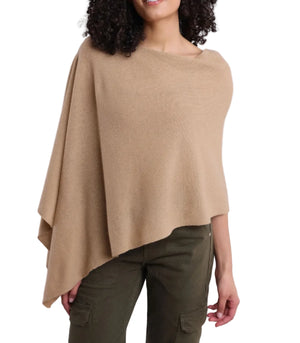 A woman wears the Alashan Cashmere Cashmere Dress Topper Poncho in beige, paired with olive green cargo pants, standing against a plain white background—a versatile wardrobe staple ideal for effortless day-to-night transitions.