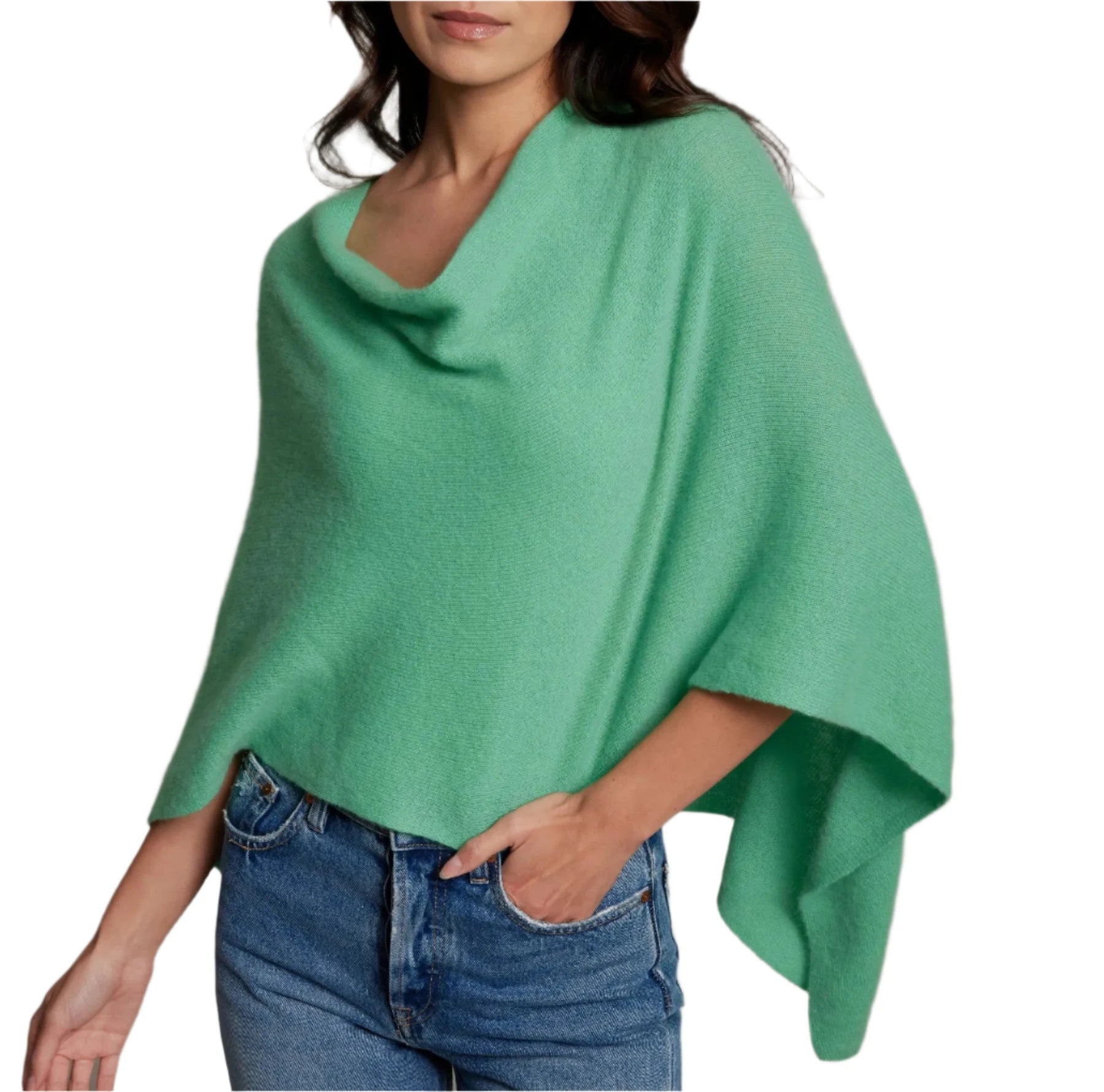 A woman dressed in the Alashan Cashmere Dress Topper Poncho paired with blue jeans, her hand casually tucked in her pocket, provides the ideal wardrobe piece for a seamless day-to-night transition against a white background.