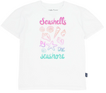 The Feather 4 Arrow Girls’ Oversized Tee is made from premium cotton and features pastel illustrations of seashells along with the phrase “Seashells by the seashore” in pink, purple, and teal.