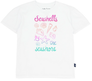 The Feather 4 Arrow Girls’ Oversized Tee is made from premium cotton and features pastel illustrations of seashells along with the phrase “Seashells by the seashore” in pink, purple, and teal.