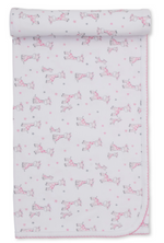 White Pima cotton baby blanket featuring pink and gray cartoon giraffes, stars, and scalloped pink trim, partially rolled at the top—an adorable addition to your nursery from the Kissy Kissy Just Giraffes Printed Blanket collection.