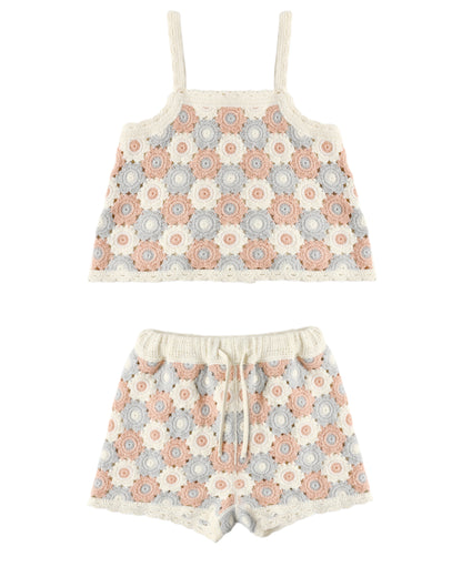The Girls' Lili Knit Set by Rylee & Cru is a two-piece summer crochet outfit with a sleeveless crop top and drawstring shorts, showcasing pink, blue, and beige floral circular motifs for a breezy style.