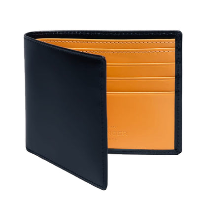 The Ettinger Bridle Billfold 6 Credit Card Wallet features black English bridle leather with an open flap, revealing multiple orange card slots inside and exemplifying the brand's traditional craftsmanship.