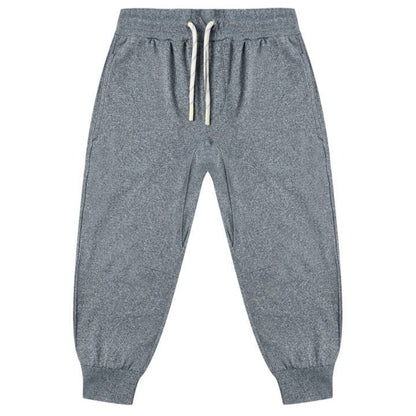 The Boys' Century Tech Jogger by Rylee & Cru features an elastic waistband, white drawstrings, side pockets, and ribbed cuffs for a relaxed fit. Versatile gray joggers shown laid flat on a white background.