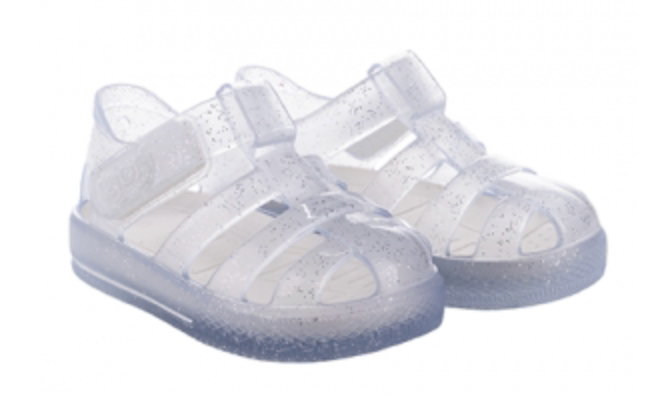 The Igor Girls' Star Jelly Sandal features translucent, glittery PVC material with adjustable straps and closed toes.