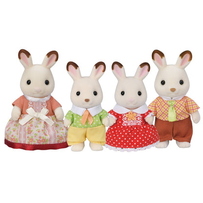 Four Calico Critters Chocolate Rabbit Family figures, each wearing colorful outfits—two in dresses and two in shirts and pants—stand in a row against a plain white background. These posable toys from the beloved Chocolate Rabbit Family make charming collectibles and inspire imaginative play.