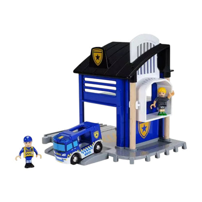 Brio Police Station playset with a blue station building, prison cell, police van, and two mini figures—one in uniform and one in casual clothes.