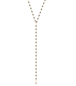 The Gigi Clozeau Party Y Necklace 19.7" from Gigi Clozeau is embellished with black beads and a stunning drop pendant, complete with shimmering resin pearls, all set elegantly against a white backdrop.