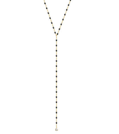 The Gigi Clozeau Party Y Necklace 19.7" from Gigi Clozeau is embellished with black beads and a stunning drop pendant, complete with shimmering resin pearls, all set elegantly against a white backdrop.